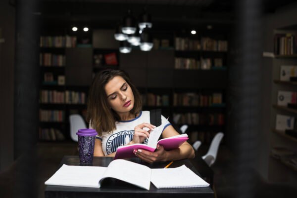 Estudante folheando páginas em mesa de estudo